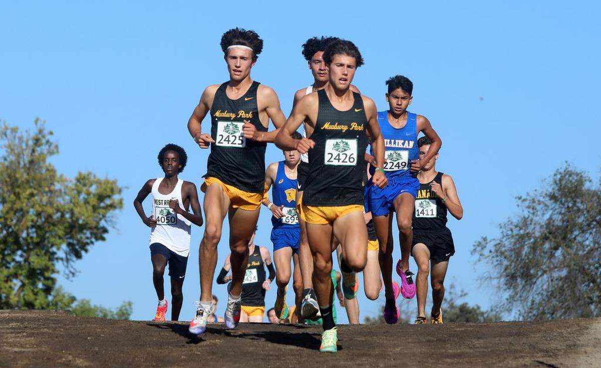 Newbury Park seniors and twins Leo Young (left) and Lex Young head toward the 1-mile mark during the boys championship race of the 43rd Asics Clovis Invitational at Woodward Park on Oct. 8, 2022. Leo Young won in 14:25.9, and Lex Young was second in 14:31.7.