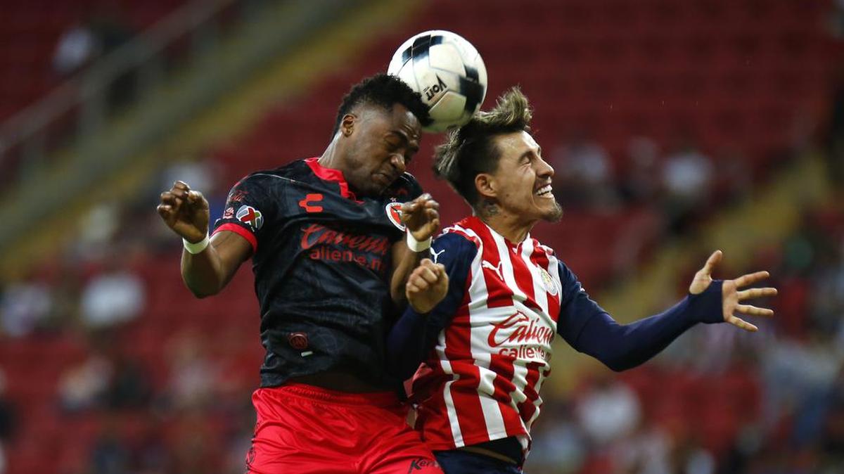 Cristián Calderón (d) de Chivas disputa el balón con Alex Ibarra (i) de Xolos hoy, durante un partido de la jornada 15 del Torneo Clausura 2022 de la liga de fútbol mexicano entre Chivas y Xolos disputado en el Estadio Akron, en Guadalajara, Jalisco.