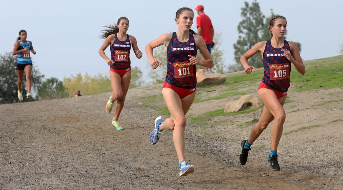 Buchanan High juniors Sydney Sundgren (105) and Grace Hutchison lead freshman teammate Elliana Lomelí as they head toward the 1-mile mark of the CIF Central Section girls Div. I race.