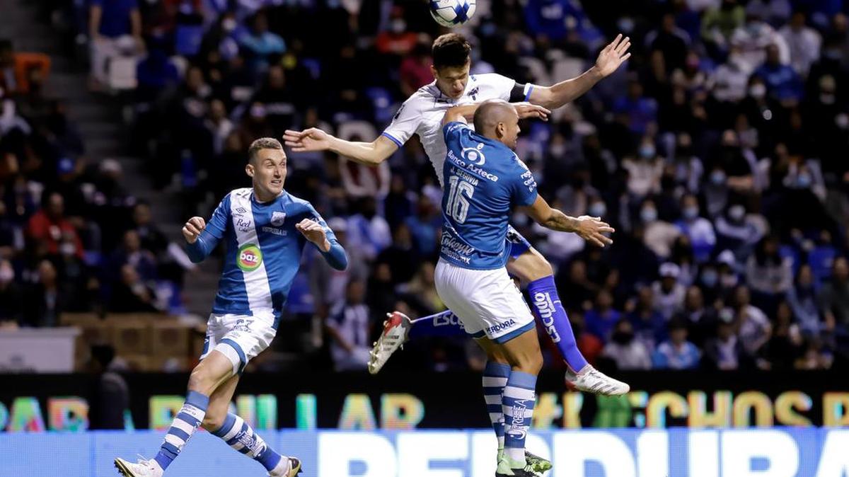 Juan Segovia (abajo) de Puebla y Claudio Kranevitteri (arriba) de Monterrey disputan un balón durante un partido de la jornada 6 del torneo Clausura 2022 del fútbol mexicano, disputado en el estadio Cuauhtémoc, en Puebla.