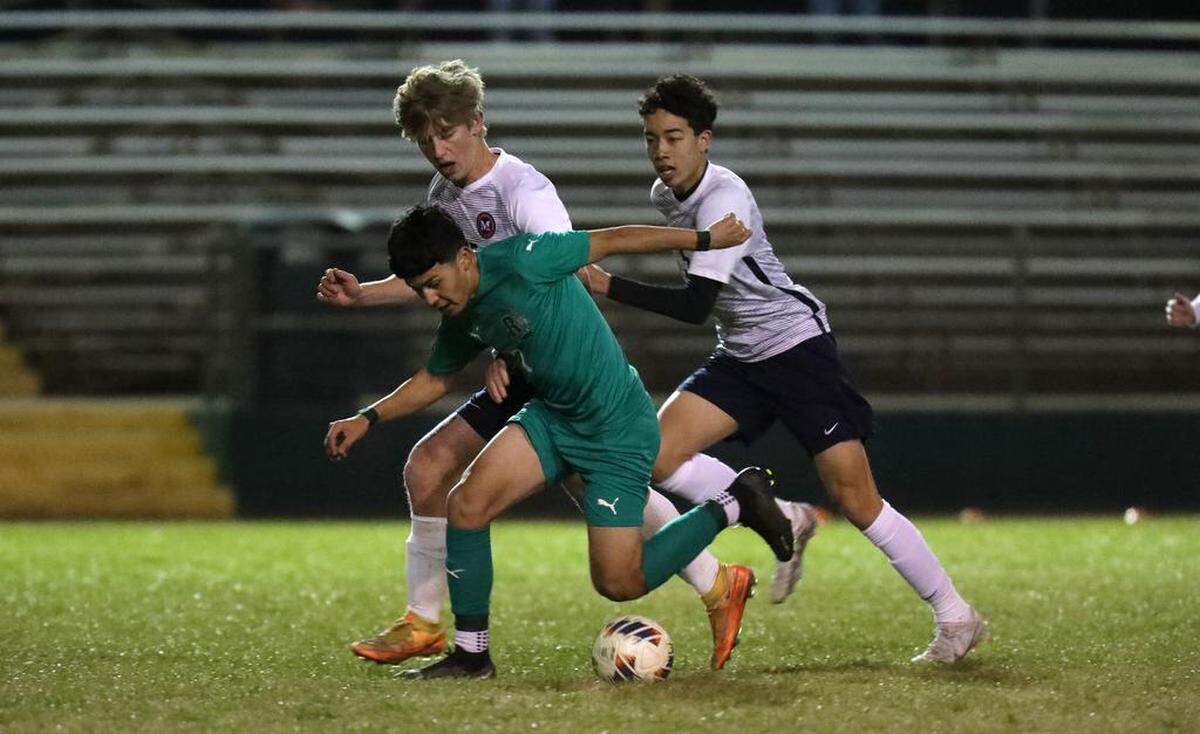 Riverdale High junior Juan Rodríguez gets pressured by the San Joaquín Memorial defense during a CIF Central Section Division IV boys soccer playoff match at Riverdale. The top-seeded Riverdale Cowboys advanced with a 1-0 win to improve to 18-4-4.