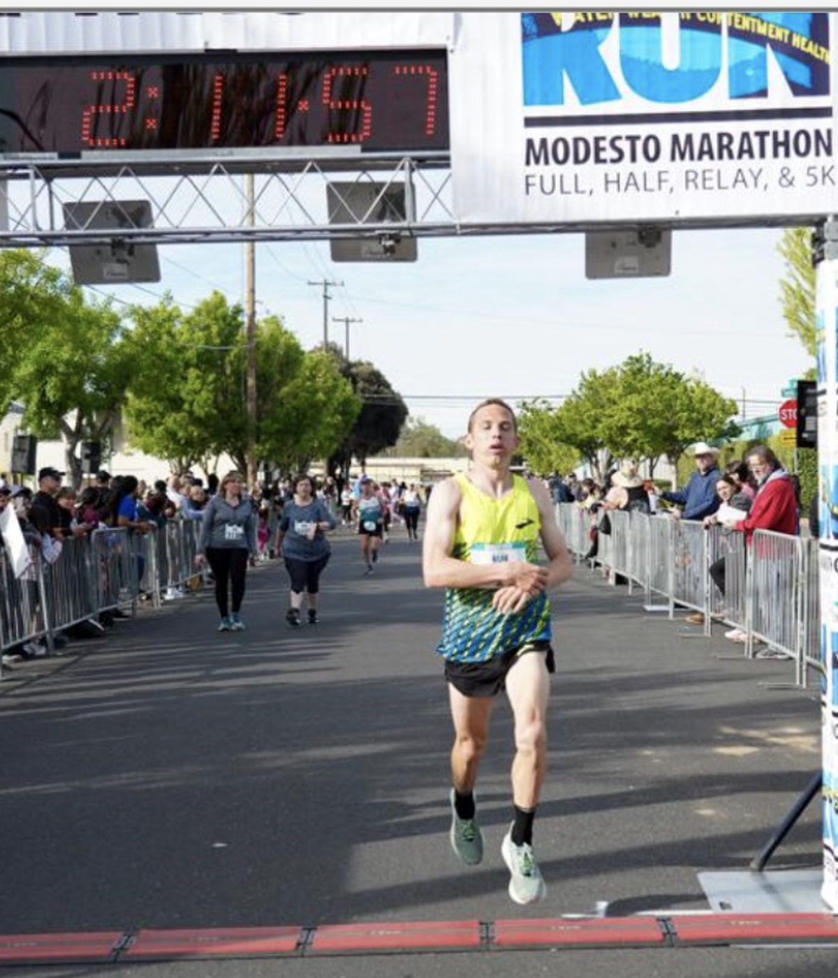 This photo shows CJ Albertson crossing the finish line at about the 2 hour, 11 minutes, 57 second mark. He ran an extra 400 meters when a motorcycle official led him off course.