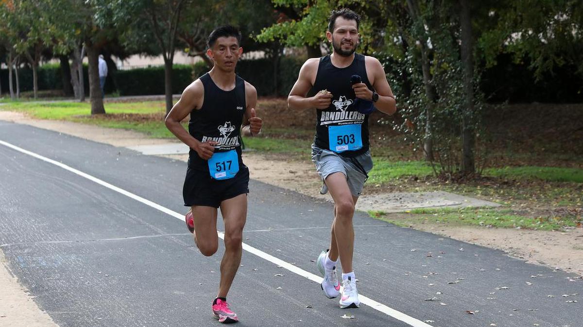Oscar Pérez and Edgar Bolaños run stride for stride as they approach the 24-mile mark of the Two Cities Marathon on Nov. 7, 2021. Bolaños won the race.