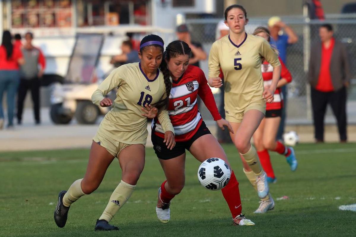 Salinas High senior Nancy Salinas leans into Kerman High sophomore Kaylee Rocha.