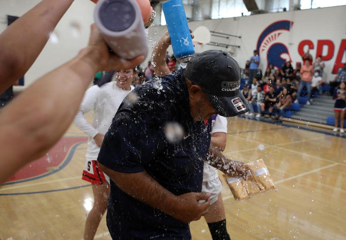 Strathmore High girls basketball coach Richard Miranda gets doused with water after guiding his team to the CIF Central Section Dvision V title after a 73-60 win over Corcoran High on June 10, 2021.