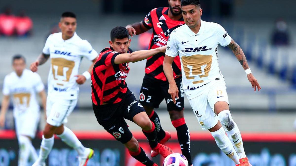 Leonel López (d), de Pumas, conduce el balón ante la marca de Marcel Ruiz (i), de Tijuana durante un juego de la jornada 15 del Torneo Apertura 2021 del fútbol mexicano en el estadio Universitario de la Ciudad de México.