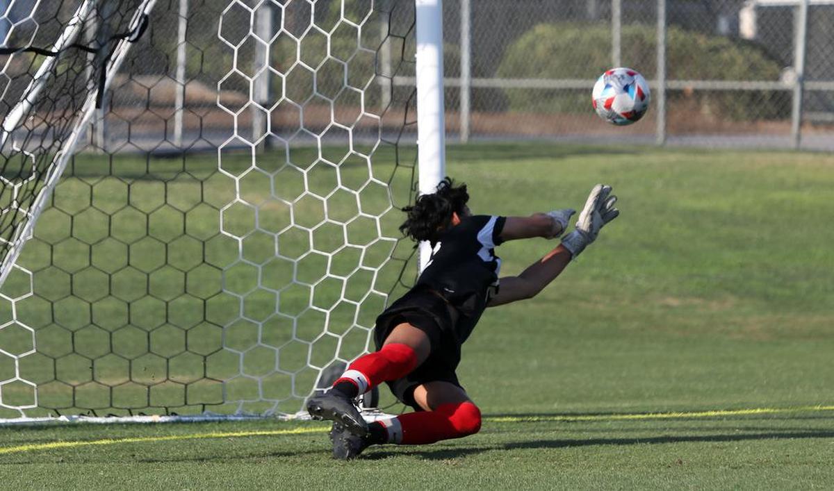 Hart High junior goalkeeper Jaime González sends a shot away.