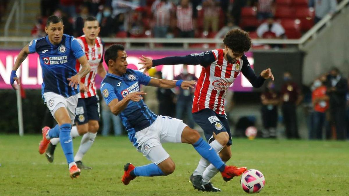 César Huerta (d) de Chivas disputa el balón con Rafael Baca de Cruz Azul durante un partido de la jornada 15 del Torneo Apertura 2021 del fútbol mexicano, disputado en el Estadio Akron, en Guadalajara.