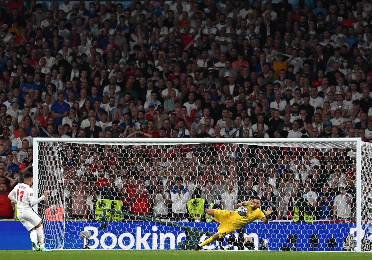 Goalkeeper Gianluigi Donnarumma of Italy saves the penalty of Jadon Sancho of England during the penalty shoot-out of the UEFA EURO 2020 final between Italy and England in London.