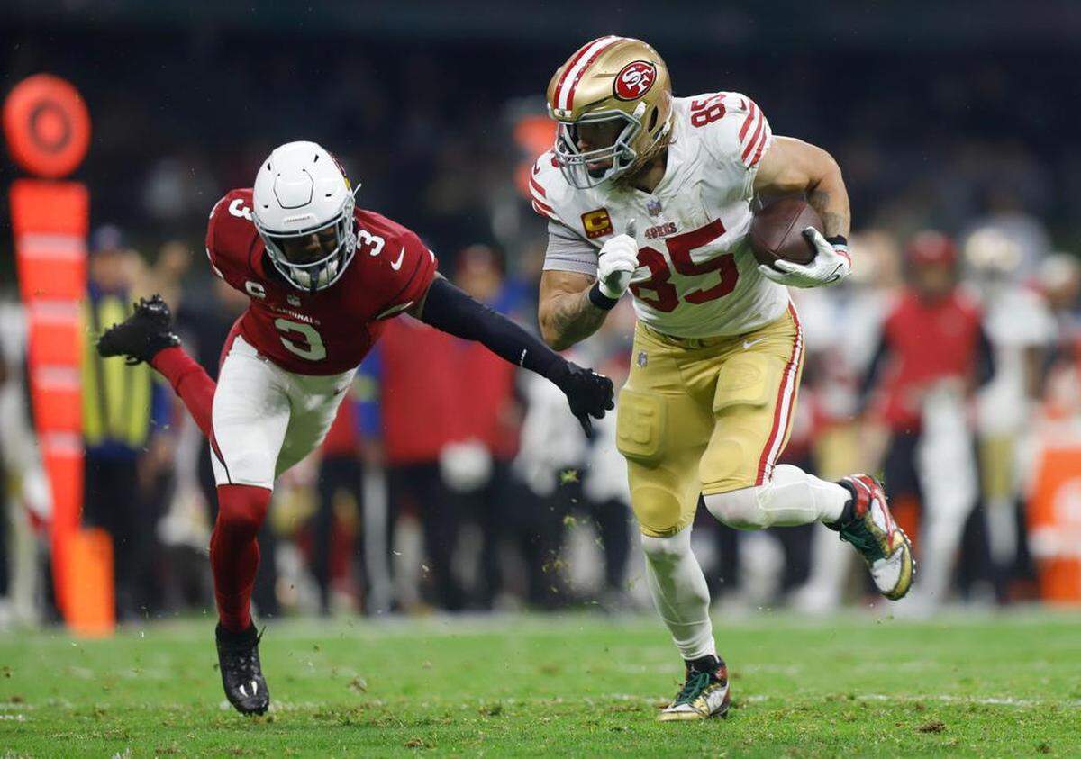 George Kittle (d) de los San Francisco 49ers en acción hoy contra Budda Baker de los Arizona Cardinals, durante un juego por la semana 11 de la NFL en el Estadio Azteca en Ciudad de México.