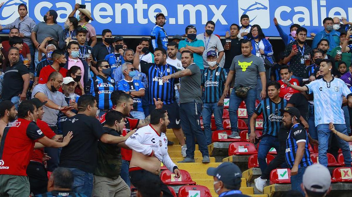 Aficionados de Querétaro y Atlas se enfrentan durante un juego correspondiente a la jornada 9 del Torneo Clausura 2022 de la Liga MX del fútbol mexicano en el estadio Corregidora de la ciudad de Querétaro.