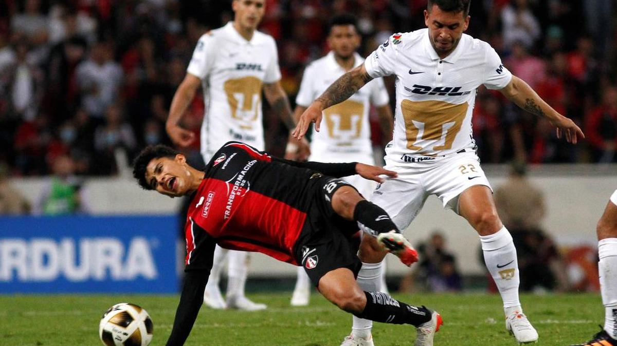 Jeremy Márquez (i) de Atlas disputa hoy el balón con Cristian Battocchino de Pumas, durante la vuelta de la semifinal del Torneo Apertura 2021 de la Liga MX, en el Estadio Jalisco, en Guadalajara.
