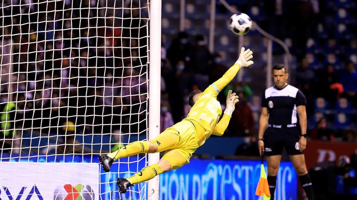 Antony Silva de Club Puebla desvía un tiro penal ante Guadalajara, durante un partido de reclasificación del Torneo Apertura 2021 de la Liga MX del fútbol mexicano en el estadio Cuauhtémoc de la ciudad de Puebla.