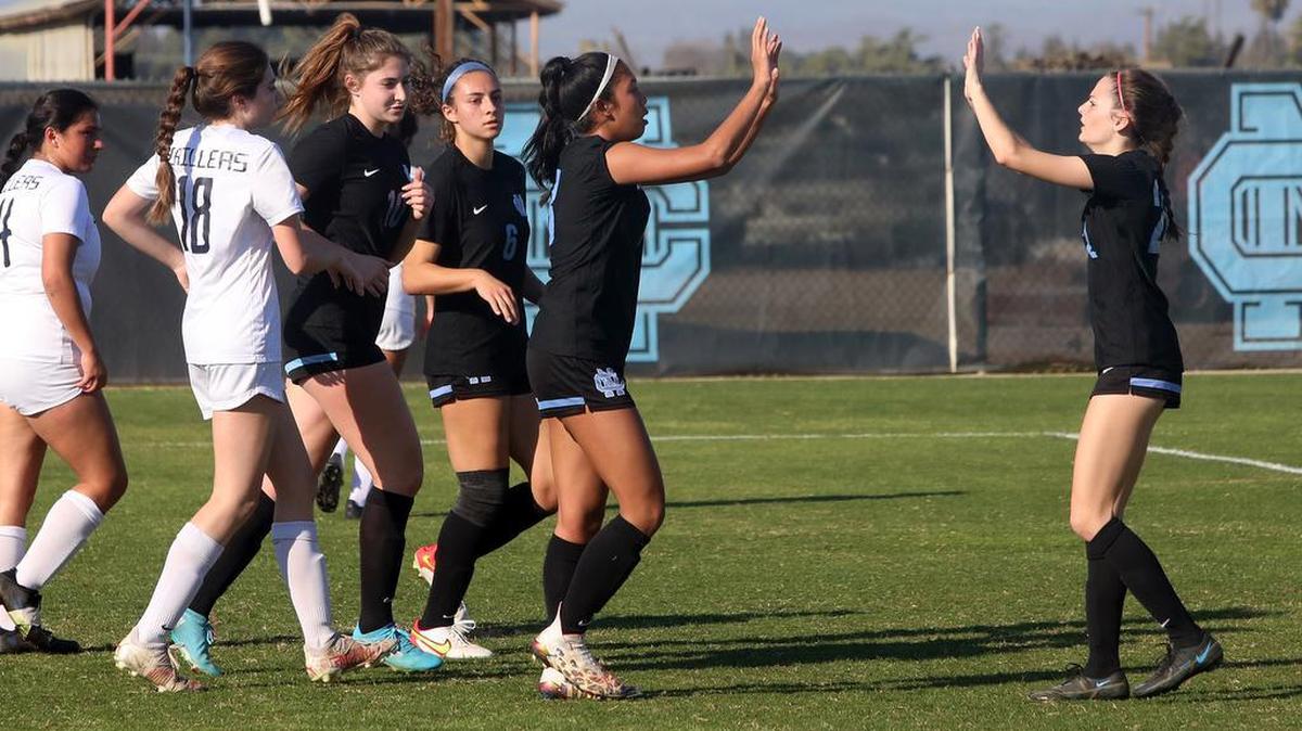 Clovis North senior Mary Ramírez is greeted by teammates after a first-half goal against Bakersfield High on Feb. 17, 2022.