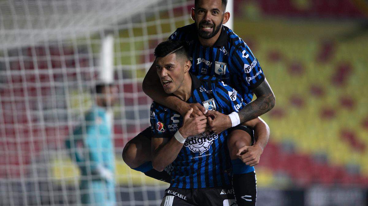 Leonardo Sequeira (i), del Querétaro, fue registrado este jueves al celebrar, con su compañero Enzo Martínez, un gol que le anotó al Atlético San Luis, durante un partido de la jornada 11 del Torneo Clausura 2022 de la Liga MX del fútbol en México, en el Estadio Morelos, en la ciudad de Morelia. EFE/Iván Villanueva