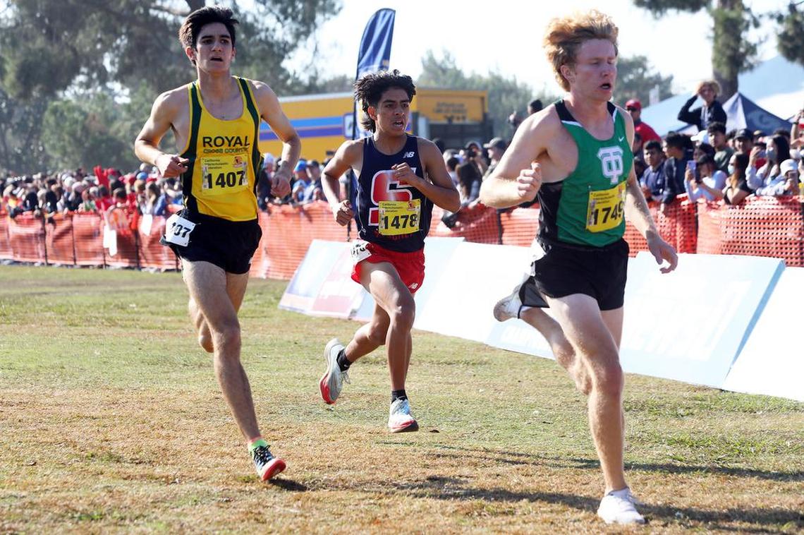 Royal High senior Jonah Bazerkanian (9th, 15:37.9), Sanger High senior David DeLoera (10th, 15:38.0), and, Thousand Oaks High senior Atticus Hall (8th, 15:37.6) are bunched up at the end of the boys Division II race on Nov. 27, 2021 at Woodward Park.