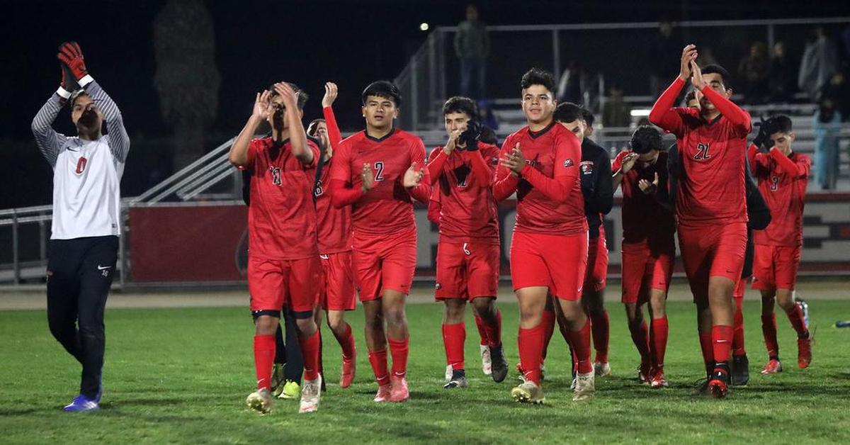 The Kerman High boys soccer team applauds their fans after a 2-0 opening round win over visiting Madera High.