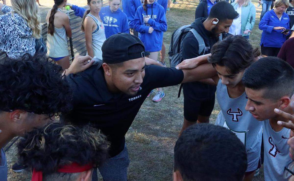 Matilda Torres High (Madera) head coach José Herrera talks with his runners after they finished third in the boys M Vasrsity race of the 43rd Asics Clovis Invitational at Woodward Park on Oct. 8, 2022.