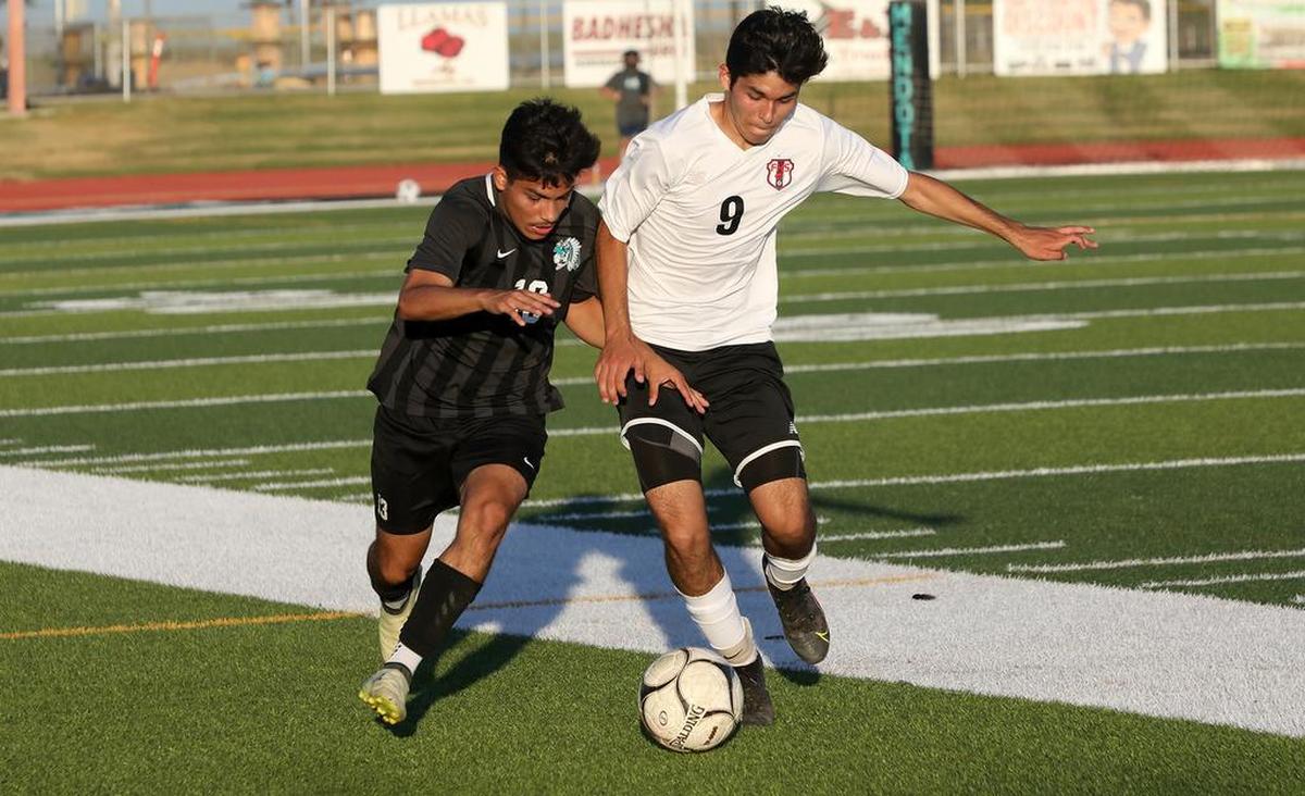Mendota High senior defender Jonathan Pérez challenges Fowler High junior midfielder Ashton Escamilla for the ball.