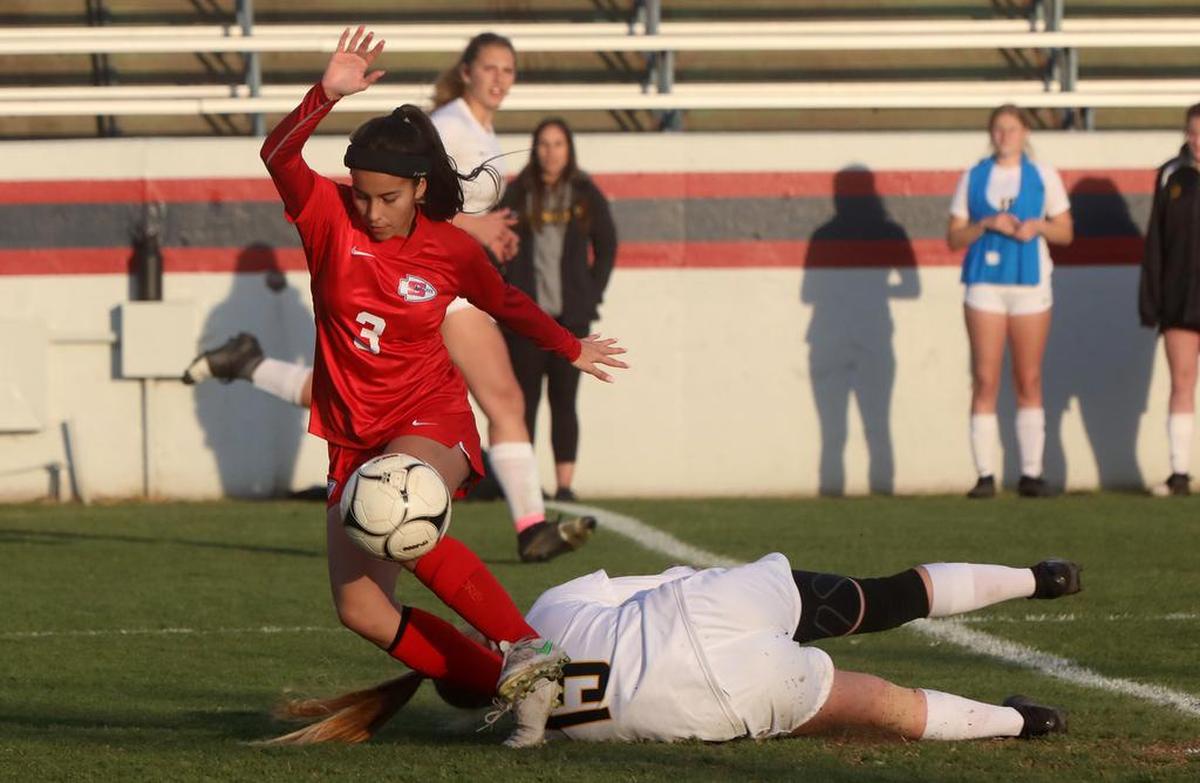 Kiana Alcántar of Sanger High gets past a fallen Ashley Brewer of San Luis Obiscpo.