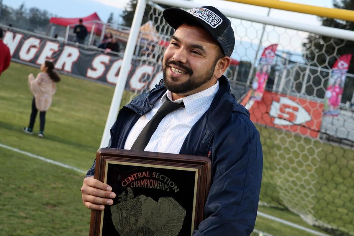 Sanger High girls soccer head coach Ángel Cabral is all smiles after the Apaches defeated San Luis Obispo for the CIF Central Section Division II championship at home on Feb. 26, 2022.