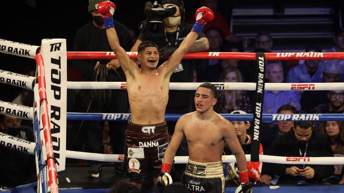 Abraham Montoya of México raises his arms in triumph while junior lightweight opponent Gabriel Flores Jr. shows little emotion at the end of their bout at the Save Mart Center on March 4, 2022. Flores Jr. won in a majority decision.