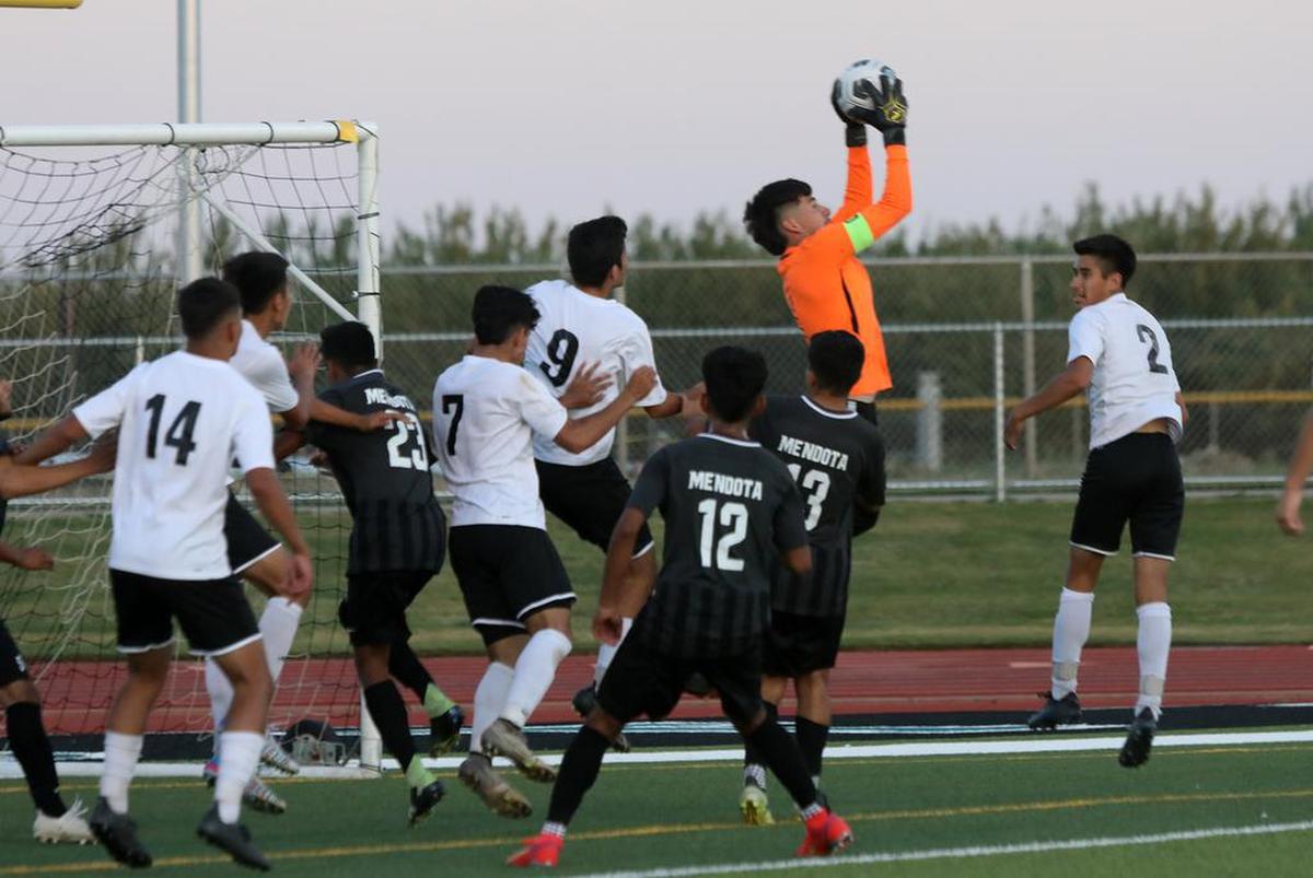 Mendota High senior goalkeeper Cresencio Arreola snatches a corner kick during Division V title game against Fowler High.