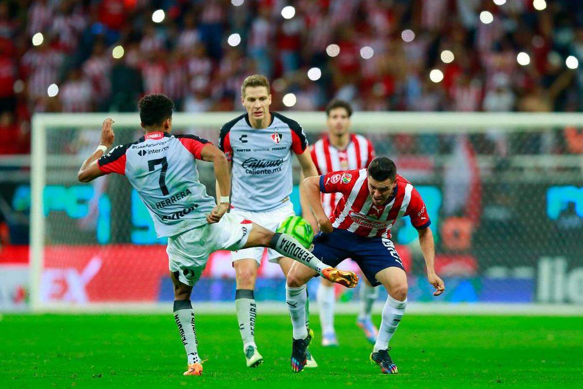 Alan Torres (d) del Guadalajara disputa el balón con Ozziel Herrera de Atlas, durante un partido por los cuartos de final del torneo Clausura 2023 de la Liga MX, en el Estadio Akron en Guadalajara el 14 de mayo.