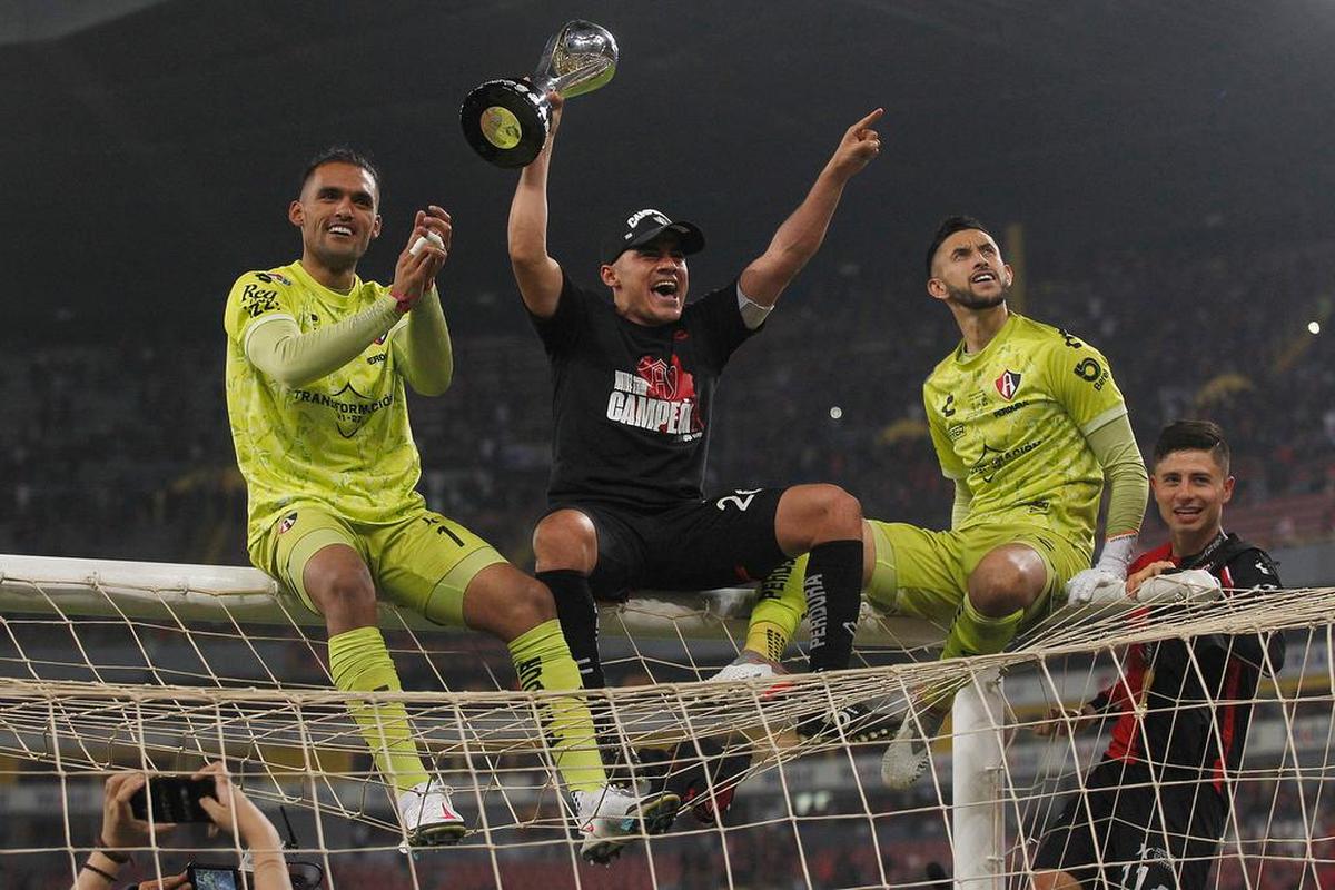 José Hernández (i), Aldo Rocha (c) y Camilo Vargas (d) del Atlas festejan con el trofeo de campeón, al término del partido por la final del torneo Apertura 2021 de la Liga MX entre Atlas y León, en el estadio Jalisco, de la cuidad de Guadalajara.