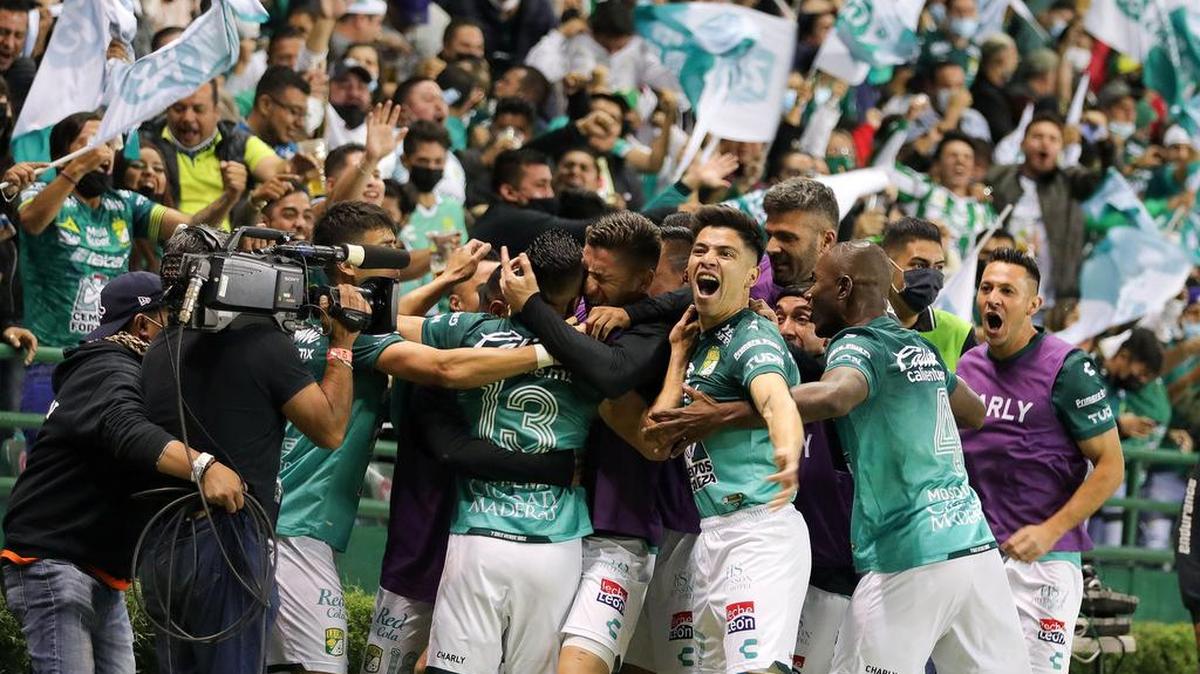 Jugadores del León celebran, este 4 de diciembre de 2021, tras anotar contra Tigres UANL, durante la vuelta de las semifinales del torneo Apertura 2021 de la Liga MX, en el estadio León.