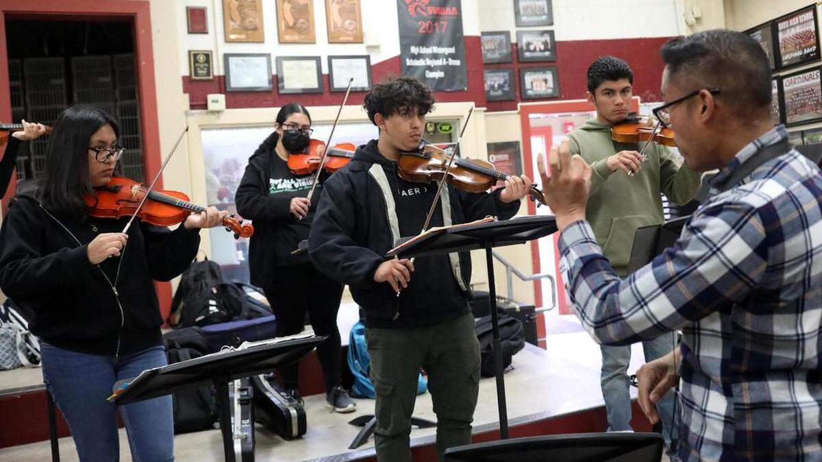 Orosi High School Mariachi Cardenal violin players listen tomariachi band director Jonathan Gaspar during class on March 15, 2023.