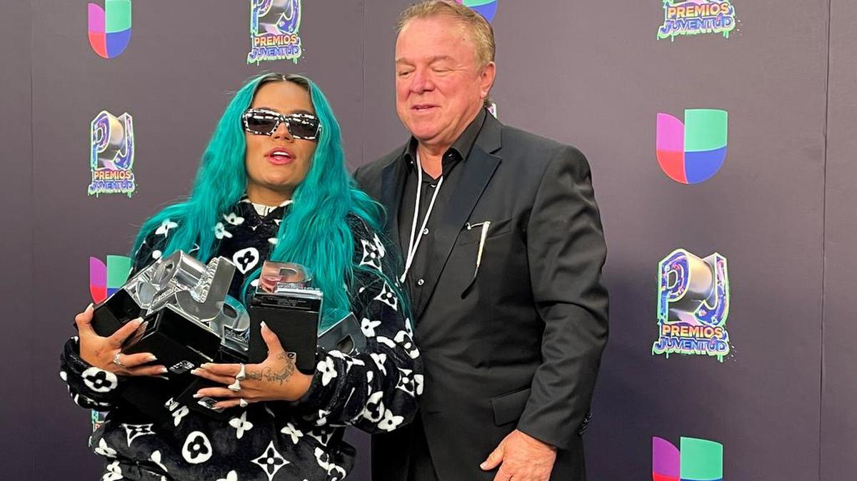 La cantante colombiana Karol G posa con sus premios junto a su padre Guillermo Giraldo al final de la gala de entrega de los Premios Juventud en el Watsco Center, en Coral Gables, Florida.