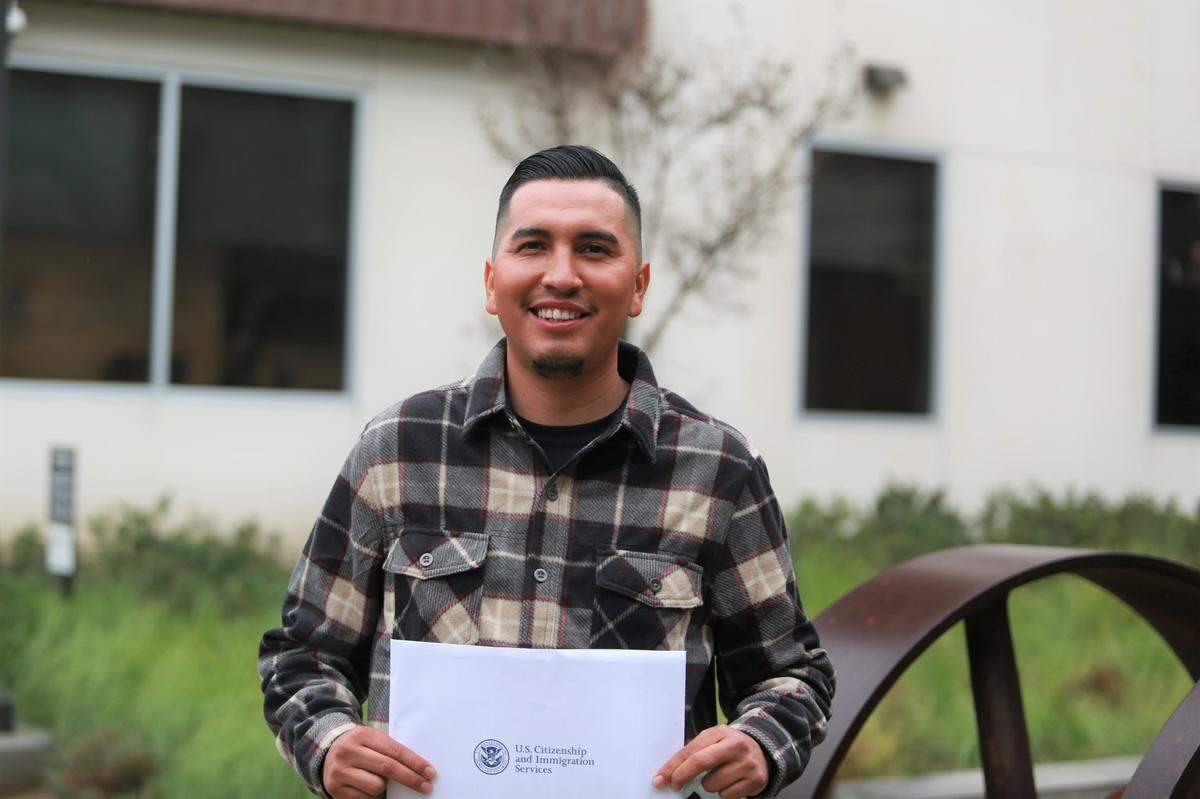Ángel Aguilar, 25 años, quien es originario del estado de Michoacán, México y vive en el pueblo de Orosi, fue uno de los 153 residentes del Valle Central provenientes de 24 países que tomaron juramento a la bandera de los Estados Unidos durante una de las pequeñas ceremonias programadas el 16 de diciembre en la Oficina del Servicio de Ciudadanía e Inmigración de Estados Unidos (USCIS) en Fresno.