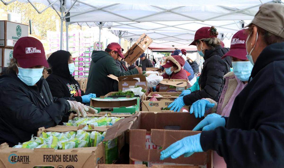 Volunteers sort food into foxes during the distribution of food to about 400 families who were impacted by flooding in Planada. The distribution by the United Farm Worker took place at César E. Chávez Middle School on March 26, 2023.