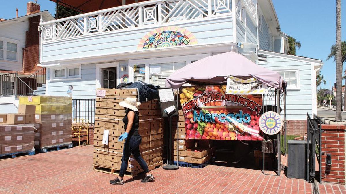 Julie Bautista, quien dirige la despensa de alimentos en el Mercado El Sol, se apresura a organizar los productos el 25 de junio de 2021.