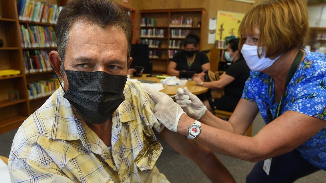 Dairy worker Jose Mariscal gets his COVID-19 vaccination from Tulare County registered nurse Cynthia Norvill during a clinic at the Tipton Library on July 29, 2021. He said has become worried about the spread of the disease and was doing it to protect his family.