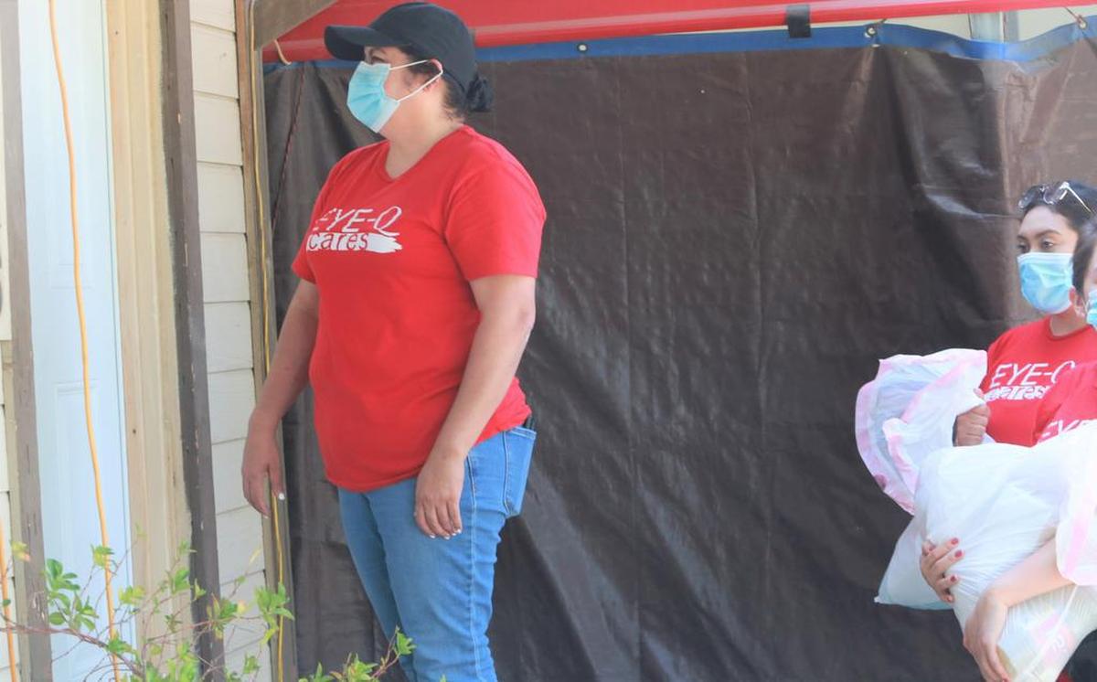 Sandy Rodríguez,&nbsp;una de las voluntarias que&nbsp;acompañaron&nbsp;a Armando Valdez a repartir&nbsp;despensas de comida el 25 de julio habla con una persona en la puerta en una de las casas en Tres Piedras.