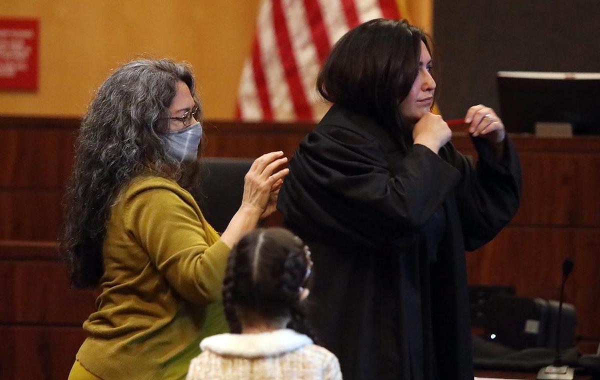 New Fresno County Superior Court Judge Irene Luna gets help from her mother in donning the judge’s robe on Dec. 13, 2021.