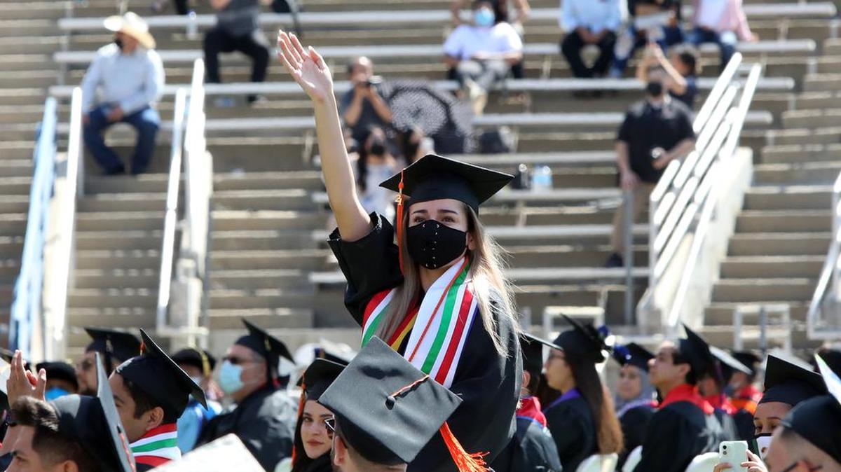 Alejandra Leija, the Fresno State undergraduate dean’s medalist from the Lyles College of Engineering, waves during the May 16, 2021 commencement at Bulldog Stadium.