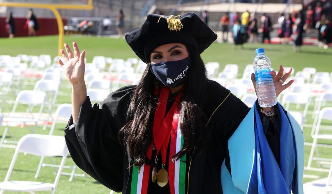 Dr. Karina Rodríquez, head counselor at Sunnyside High, &nbsp;acknowledges the crowd while walking into the Fresno State May 14, 2021 morning commencement in Bulldog Stadium.