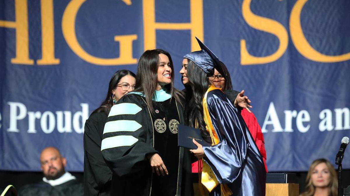 Sunnyside High School counselor Dr. Lidia Alaniz-González hands a diploma to her daughter, Krista Faith González, during the June 7, 2022 graduation ceremony at the Save Mart Center.