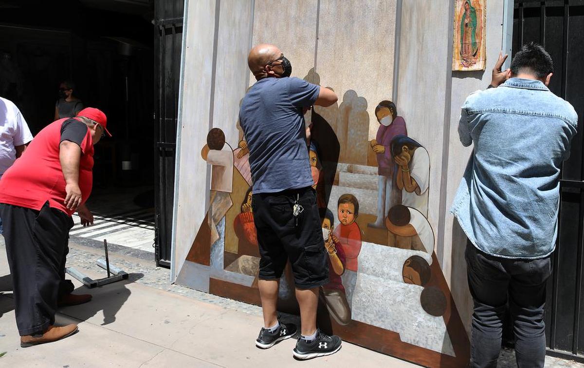 Volunteers set up the ‘Children in Cages’ portable mural outside Teocalli Cultural Academy in downtown Fresno on May 16, 2021.
