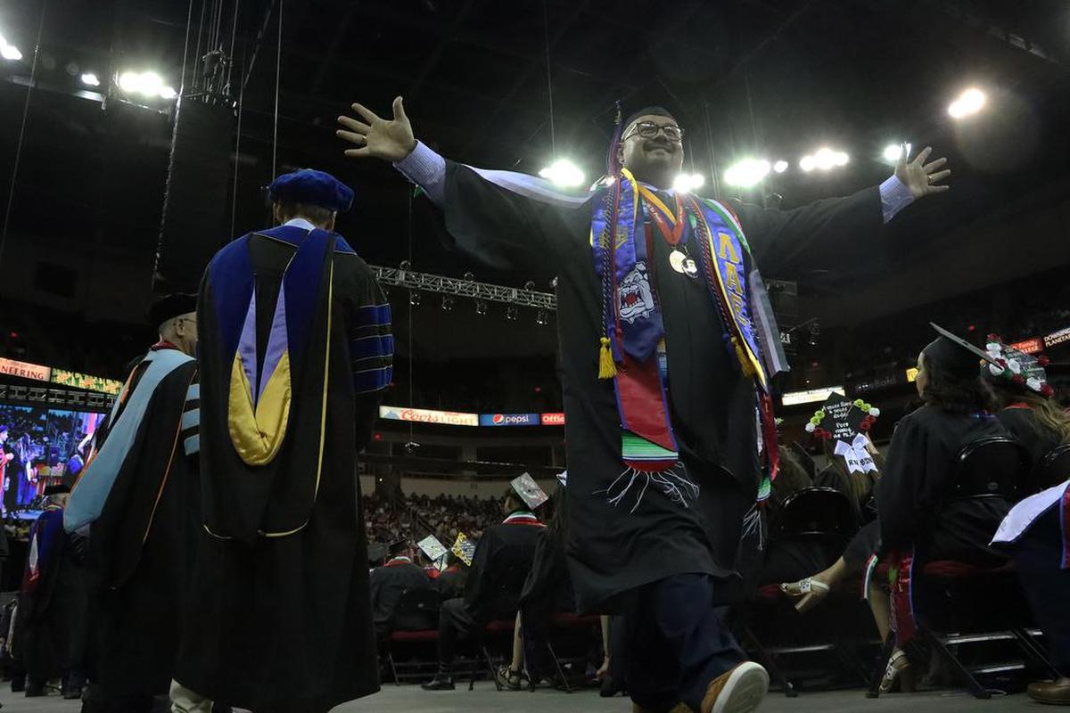 Un graduado de Fresno State disfruta bajo las luces en la Celebración de Graduación Chicano/Latino del 46.º aniversario el 21 de mayo de 2022 en el Save Mart Center ante una audiencia de unas 14,000 personas.