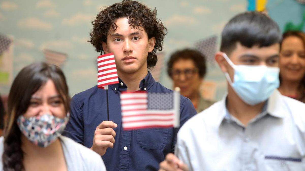 Brian Ávalos García of Visalia waves a U.S. flag after he received his naturalization certificate during Sept. 16, 2022 ceremony at the Betty Rodriguez Regional Library.