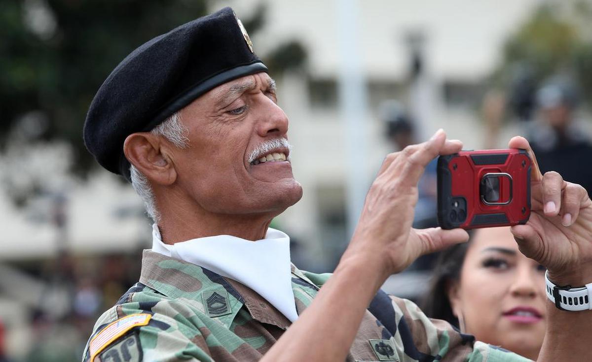 Retired Army Master Sgt. Jackie Lovato snaps a photo of dignitaries at the Central Valley Veterans Day Parade.