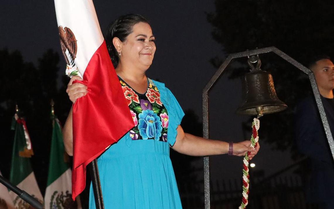 Adriana González Carillo, head consul of México in Fresno, holds the Mexican flag and rings a bell during a Sept. 15, 2022 celebration of her country's 212th anniversary of her independence.