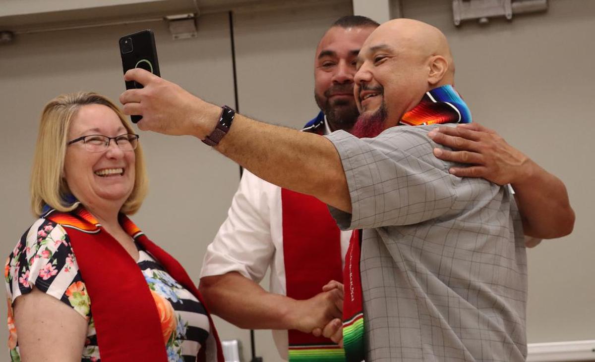 A Fresno City College graduate snaps a selfie with incoming president Robert Pimentel during the Latino Graduation Celebration inside the college gym on Saturday (May 21).