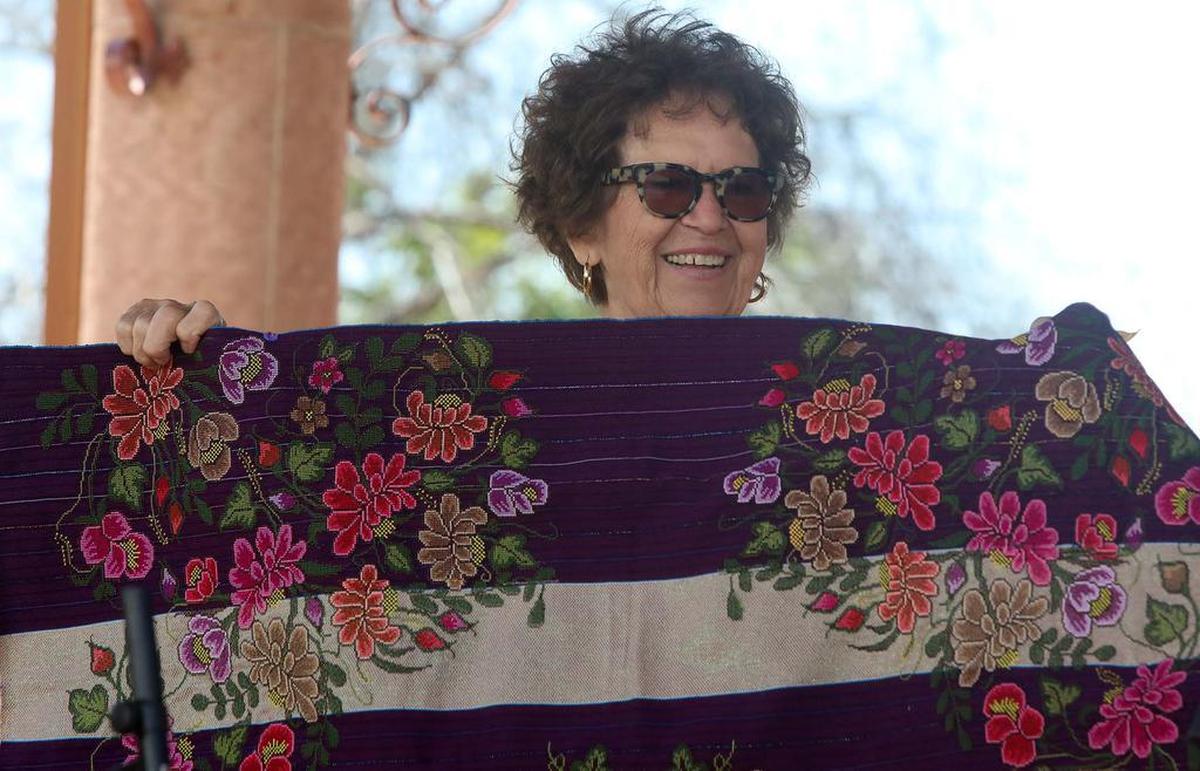 Retired high school counselor Diana Rodríquez holds up a rebozo she received after being honored as mother of the year during the Arte Américas Mother’s Day celebration on May 8, 2022.