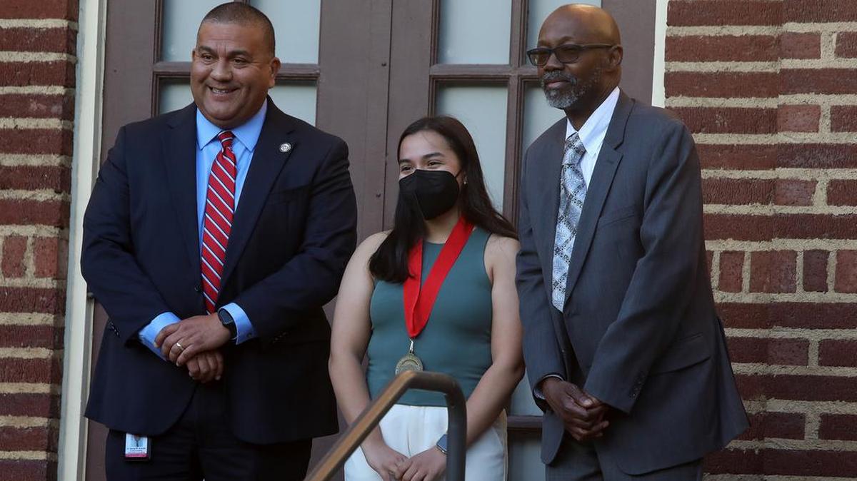 Counseling and Guidance Division interm dean George Alvarado and interim president Dr. Marlon Hall congratulate dean’s medallion recipient Faith Vega during the May 12, 2022 ceremony.