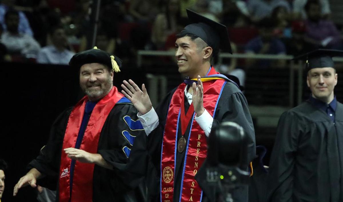 Joey Contreras, the graduate dean't medalist from the Fresno State College of Science and Mathematics, reacts after getting hooded on Friday afternoon.